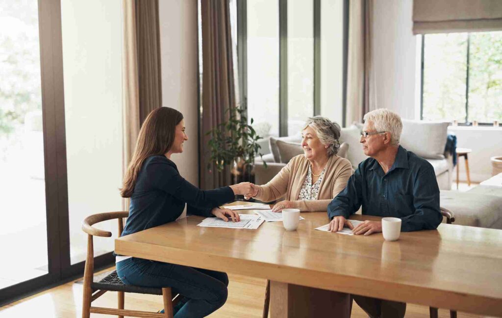 Financial advisor shaking hands with a client across a desk during a retirement planning meeting