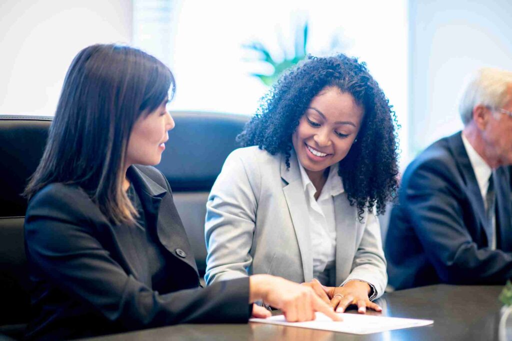 Two women reviewing paperwork during a business meeting